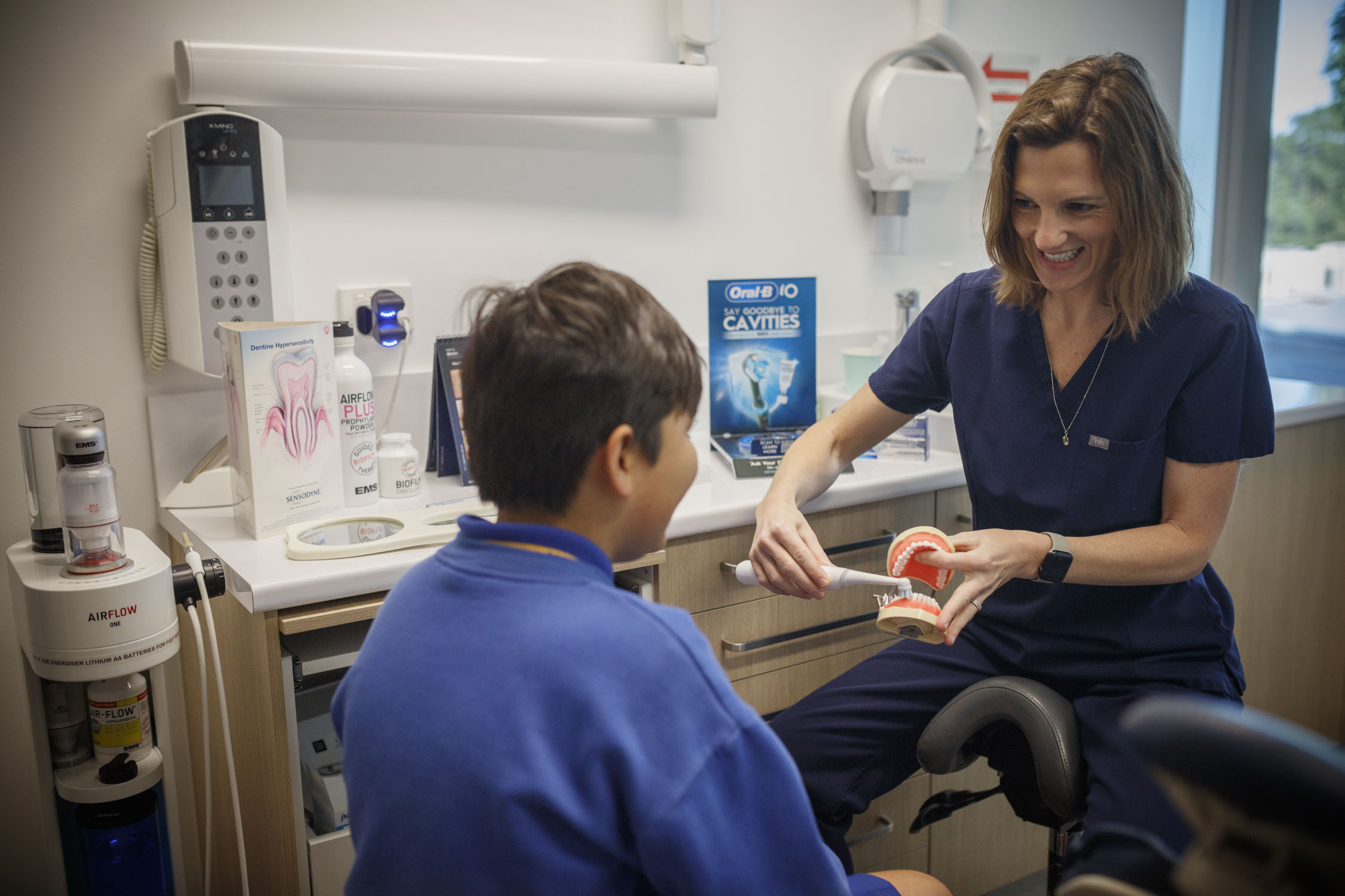 Oral Health Therapist Katie demonstrating tooth brushing to a child at Tooth Sparkler Family Dental in Frenchs Forest.