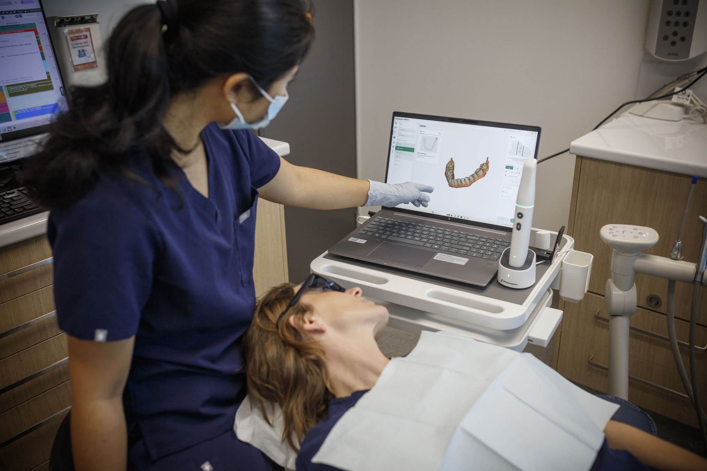 Dental clinician showing a patient a 3D scan of their teeth during a preventive dental care appointment